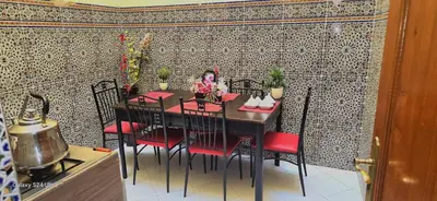 a dining room with a table and red chairs at cozy Apartment Near Airport in Marrakech