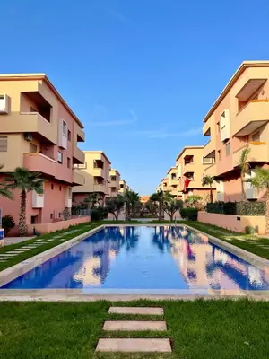 a swimming pool in front of some apartment buildings at Duplex chic et cosy avec piscine in Marrakech