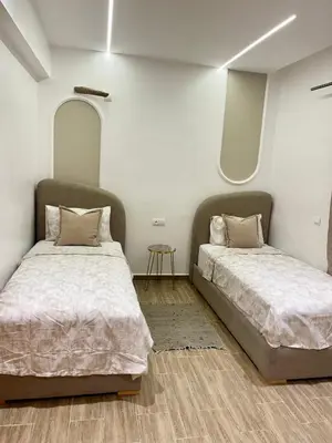 a bedroom with two beds and a mirror at Duplex chic et cosy avec piscine in Marrakech