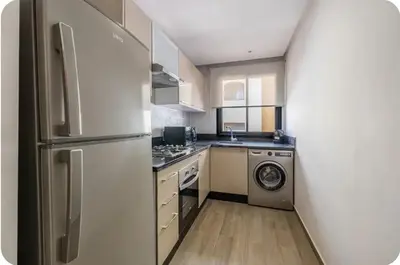 a kitchen with a refrigerator and a washing machine at Appartement en hyper Centre in Marrakech