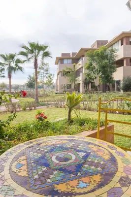 a tiled table with a painting on it in a park at Elevated Elegance A Stylish Golf Atlas Apartment in Marrakech