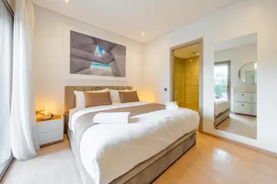 a bedroom with a large bed and a mirror at Luxury Prestigia Paradise Garden-Pool in Marrakech