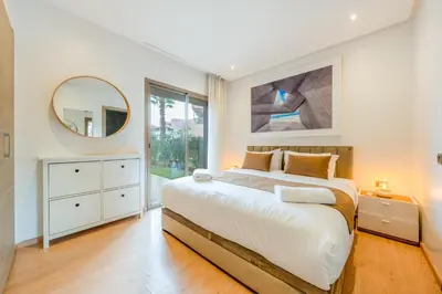 a bedroom with a large bed and a mirror at Luxury Prestigia Paradise Garden-Pool in Marrakech
