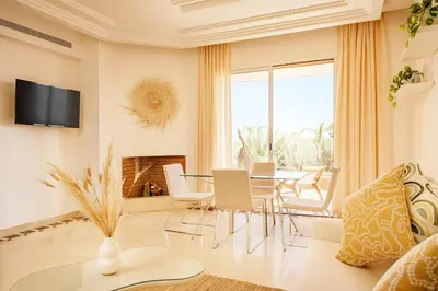 a living room with a table and chairs at Luxury Apartment in Vizir Park & Resort in Marrakech