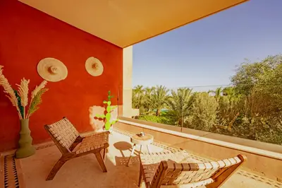 a patio with two chairs and a table and a window at Luxury Apartment in Vizir Park & Resort in Marrakech