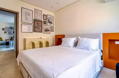 a bedroom with a large white bed with pictures on the wall at Appart Chambre et Salon Gueliz Marrakech Alia1 in Marrakech