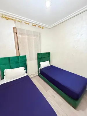 a bedroom with two beds with purple sheets and green accents at N7 Confort Cosy Près De Gueliz in Marrakech