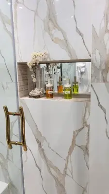 a bathroom with marble walls and a shelf with cosmetics at Le Confortable a 15mn de L'aéroport interdit au couples non marié in Marrakech