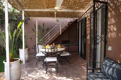 a patio with a table and chairs and a staircase at Villa Em in Marrakech