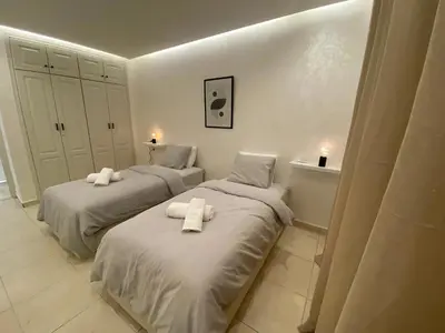two beds in a white room with towels on them at Centre ville Gueliz Plaza Marrakech in Marrakech