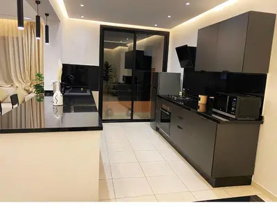 a kitchen with black cabinets and a counter top at Centre ville Gueliz Plaza Marrakech in Marrakech