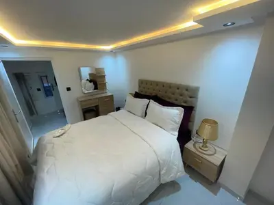 a bedroom with a large white bed and a lamp at Duplexe de luxe Gueliz in Marrakech