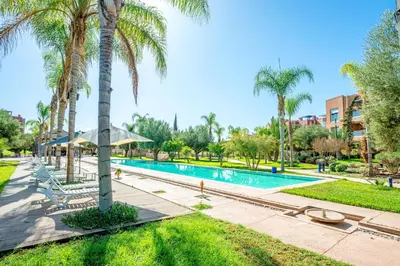 a swimming pool with palm trees and a resort at Modern Oasis with Waterpark in Marrakech