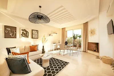 a living room with a couch and a table at Modern Oasis with Waterpark in Marrakech