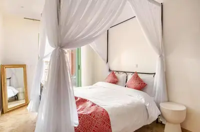a bedroom with a canopy bed and a mirror at Sojori Majorelle piscine et parking in Marrakech
