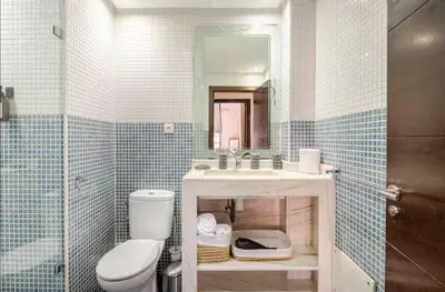 a bathroom with a toilet and a sink and a mirror at Sojori Majorelle piscine et parking in Marrakech