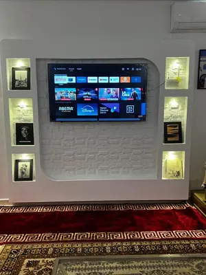 a flat screen tv on a wall with pictures at Dar Nahila Appartement Aéroport in Marrakech
