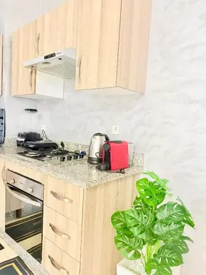 a kitchen with wooden cabinets and a plant at Charmant Studio B5 & Bel Terrasse in Marrakech