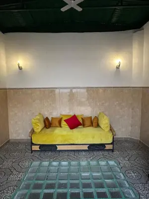 a yellow couch with red and yellow pillows in a room at 5 min Aéroport Appartement avec Terrasse et Grand Appartement in Marrakech
