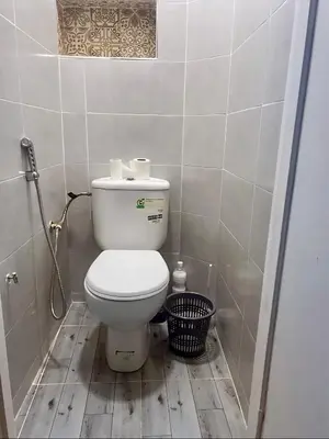 a bathroom with a toilet and a trash can at 5 min Aéroport Appartement avec Terrasse et Grand Appartement in Marrakech