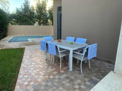 a white table and chairs with blue chairs around it at Dar Zoubida in Marrakech