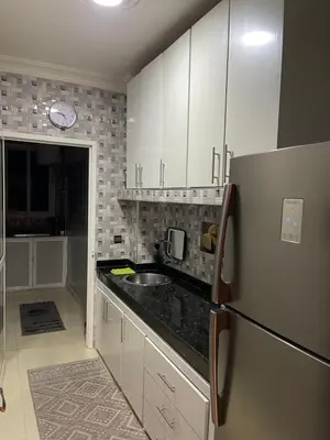 a kitchen with white cabinets and a stainless steel refrigerator at Élégant appart 2chambre, terrasses,proche Gueliz&parking in Marrakech