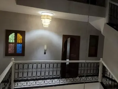a staircase with a chandelier and a stained glass window at Riad Raphia in Marrakech