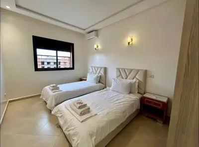 a bedroom with two beds and a window at Chic Appartement Marrakech in Marrakech