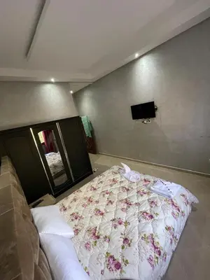 a bedroom with a bed with a floral blanket at Deluxe Private Villa in Marrakech