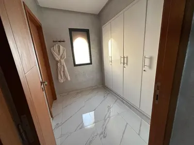 a hallway with white marble floors and a window at Villa à la palmeraie in Marrakech