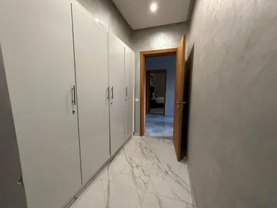 a hallway with white cabinets and marble floors at Villa à la palmeraie in Marrakech