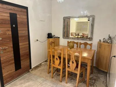 a dining room with a table and chairs and a mirror at Appartement aux portes de Marrakech in Marrakech