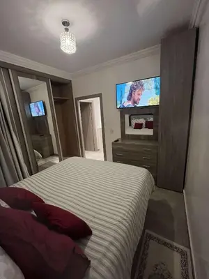 a bedroom with a bed and a flat screen tv at Appartement aux portes de Marrakech in Marrakech