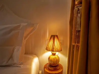 a lamp sitting on a table next to a bed at Riad Dar Al-Famila & Spa in Marrakech