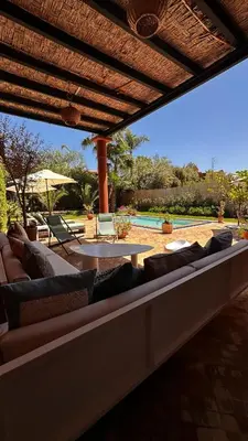 a patio with couches and a table and a pool at Dar Nadim sur le Golf de Samanah in Marrakech