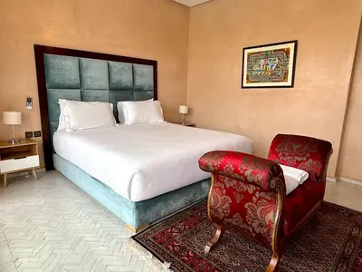 a bedroom with a large bed and a chair at Palais Bahida in Marrakech