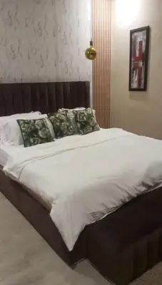 a large bed with white sheets and green pillows at Villa 4 chambres sans vis à vis in Marrakech