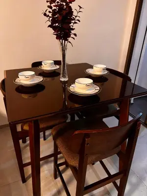 a dining room table with a vase of flowers on it at Comfy space in Marrakech