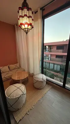 a living room with two tables and a large window at Luxueux Appartement Domaine de Noria, Wifi, Clim, Piscine, Résidence Privée in Marrakech
