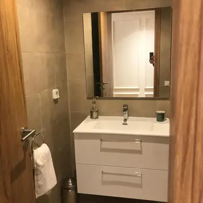 a bathroom with a white sink and a mirror at Luxueux Appartement Domaine de Noria, Wifi, Clim, Piscine, Résidence Privée in Marrakech