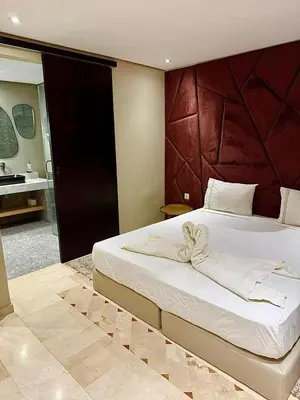 a bedroom with a large bed and a bathroom at Plaza Guéliz Prestige Apartment in Marrakech