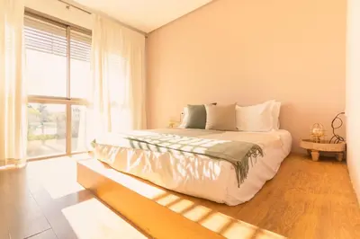 a bedroom with a large bed and a large window at Villa 5 Suites Modern with Ping Pong table and Heated Swimming pool in Marrakech
