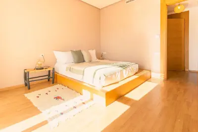 a bedroom with a bed with a table and a rug at Villa 5 Suites Modern with Ping Pong table and Heated Swimming pool in Marrakech