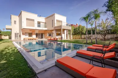 a house with a swimming pool in front of it at Villa 5 Suites Modern with Ping Pong table and Heated Swimming pool in Marrakech