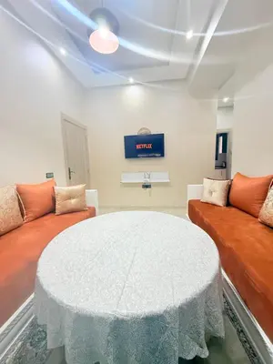 a living room with a table and two couches at Appart Abir2 N1 Confort Au Centre-ville in Marrakech