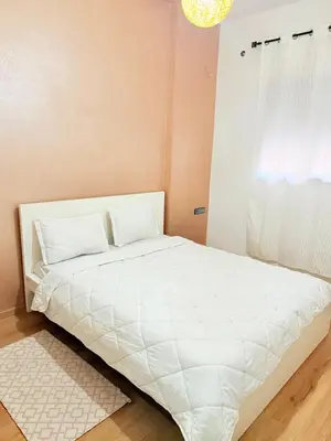 a white bed in a room with a window at Appart Abir2 N1 Confort Au Centre-ville in Marrakech