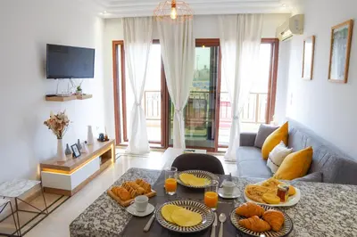 a living room with a couch and a table with food at Cosy cocon au coeur de Gueliz-Parking gratuit in Marrakech