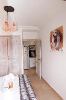a white room with a dog painting on the wall at Cosy cocon au coeur de Gueliz-Parking gratuit in Marrakech