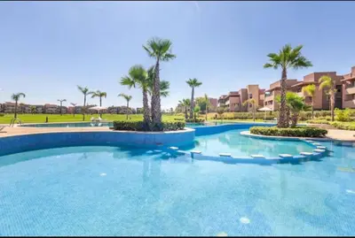 a large swimming pool with palm trees in a resort at Ali plaza marrakech in Marrakech