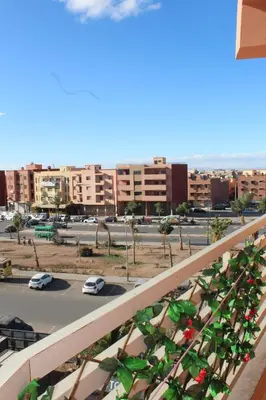 a balcony with green plants on a city street at beautiful appartement near airport in Marrakech